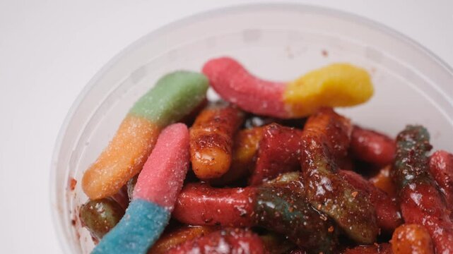 Close up of chamoy chilli gummy worms rotating on lazy susan