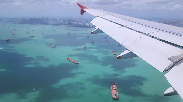 Amazing view of Singapore through the aeroplane window: the vast skyscrapers, the busy seaport, and the isolated islands.