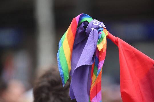 bandeira LGBTQIA+ na manifestacao em paisagem urbana em desfoque