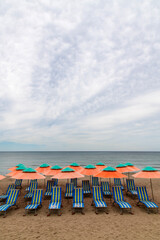 parasols and seats at the beach on a cloudy day