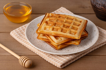 Delicious homemade waffles served on a cozy table with honey and warm light