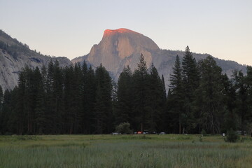 Last rays of setting sun on Half Dome in Yosemite, California