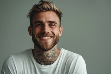 Obraz premium Smiling tattooed man in white t-shirt. Perfect for blogs, articles about men's fashion or lifestyle.