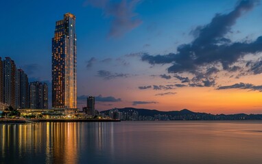 Fototapeta premium Stunning sunset view of a modern skyscraper by the waterfront in a bustling urban area
