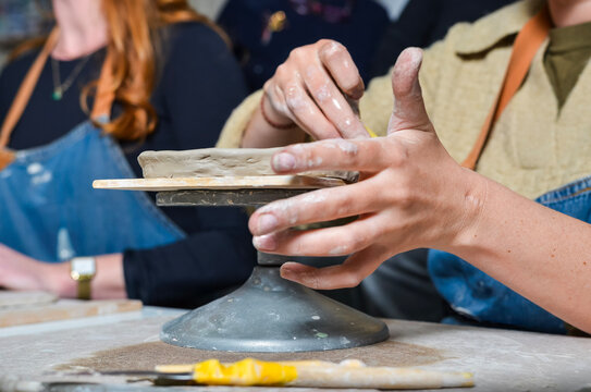Potter preparing clay on pottery wheel for shaping