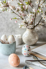 Obraz premium A beautiful arrangement of pastel-colored Easter eggs beside blooming branches, evoking the spirit of spring and celebration.