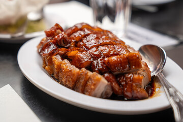 crispy pork and roasted duck is served with a caramelized glaze, embodying authentic Chinese...