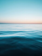 Fototapeta premium Serene Horizon Over Calm Ocean at Dusk with Gentle Waves and Soft Color Transition from Blue to Warm Pastels in Tranquil Seascape Setting