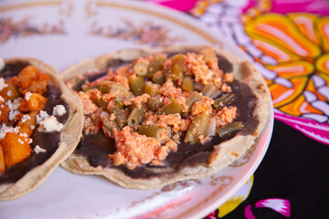 Cooking memelas in Oaxaca Central de Abastos Market with local cheese, pork and vegetables.