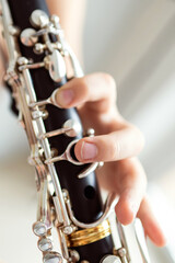 Fototapeta premium close up of child's hands playing clarinet, selective focus