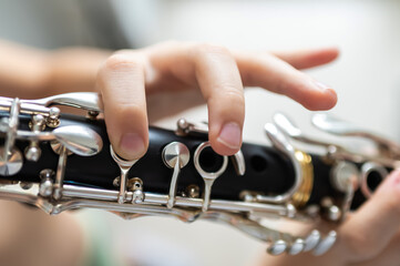 Obraz premium close up of child's hands playing clarinet, selective focus