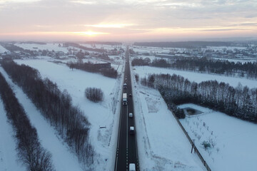 Sunset view of snowy road and forest