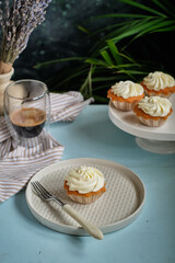 Cupcakes with vanilla cream. Blue background, side view
