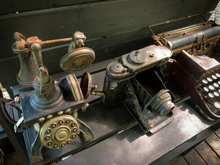Telephone, camera and old rusty antique typewriter on the table
