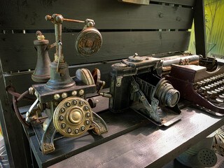 Telephone, camera and old rusty antique typewriter on the table