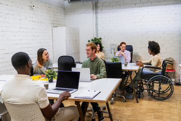 Diverse coworkers collaborating in modern office, embracing inclusion and teamwork