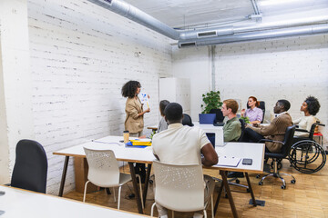 Young professionals attending presentation in modern coworking space
