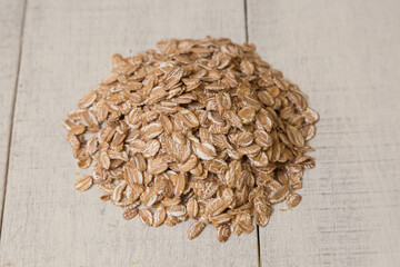 Close up of a wheat flakes on a white wooden background