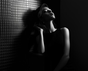 Monochrome Luxury Dramatic black and white portrait of a woman against a textured wall. Monochrome luxury studio fashion shoot