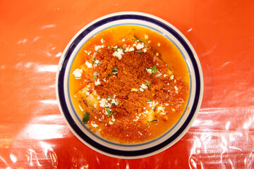 Entomatadas con chorizo are a typical Mexican dish consisting of a tortilla bathed in tomato sauce and pork meat.