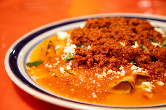 Entomatadas con chorizo are a typical Mexican dish consisting of a tortilla bathed in tomato sauce and pork meat.