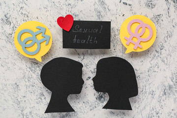 Silhouettes of boy's and girl's heads, male and female symbols and text SEXUAL HEALTH on grunge...