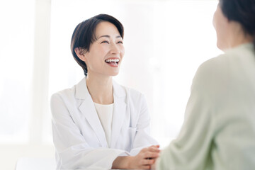 Obraz premium 白衣を着た女性が患者と話している。