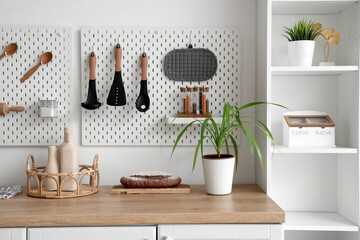Peg board over counter in kitchen. Closeup