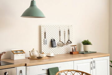 Interior of kitchen with white counter and peg board. Closeup