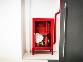 Red Fire Hose Cabinet Against Modern Wall in Indoor Setting
