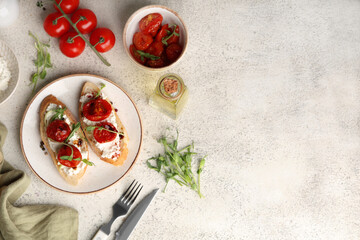 Plate of tasty tomato bruschetta with ricotta and microgreens on white background