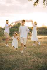 Happy male and female playing with children outside