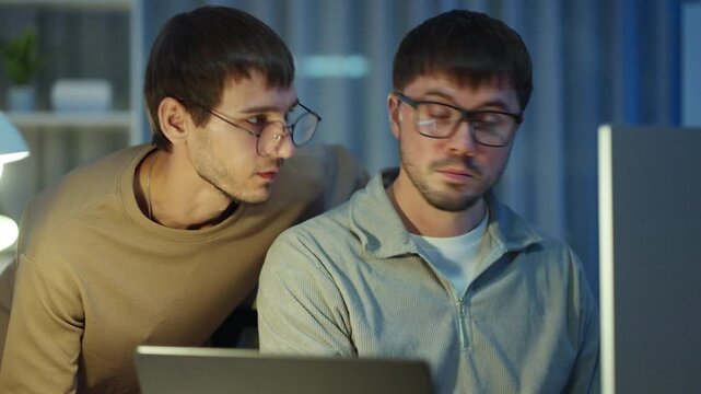 Two professionals work on a Visual Basic platform, executing tech plans and refining app features for a startup."