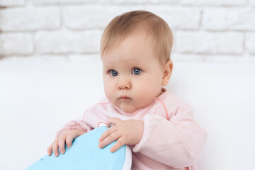 Fototapeta premium Portrait of smiling newborn baby playing toy.