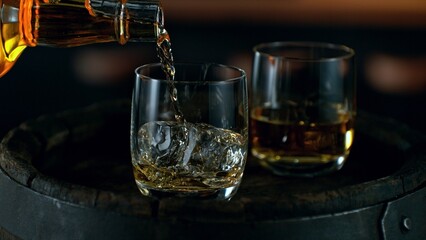 Detail of pouring whiskey into glass. Freeze motion drink preparation.