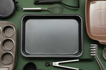Baking tray with kitchen utensils on green background. Top view