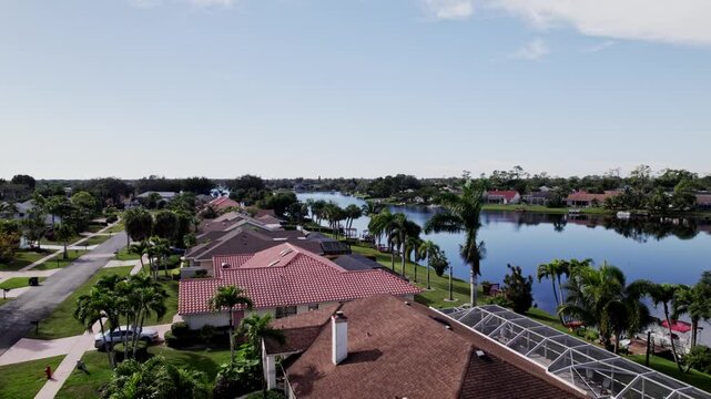 Aerial: West Palm Beach residential zone during the day with blue sky, slow push in drone shot, USA