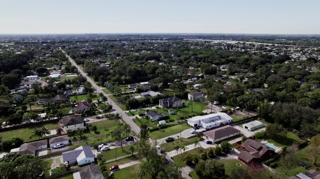 Aerial: West Palm Beach residential zone during the day, push in tilt up drone shot, USA
