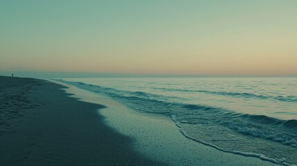 Serene sunset beach scene with gentle waves and tranquil ocean.