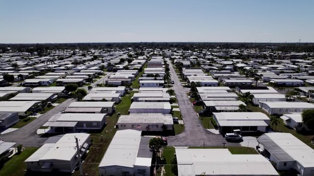 Aerial: West Palm Beach residential zone during the day with white houses, dolly in drone shot, USA