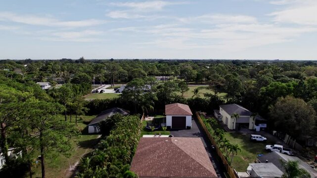 Aerial: West Palm Beach rural residential zone during the day, dolly in drone shot, USA