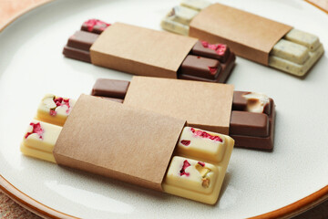Delicious chocolate bars with different flavors on light table, closeup