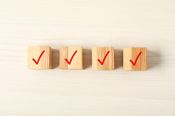 Wooden cubes with check marks on table, flat lay