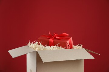 Parcel with gift box on red background