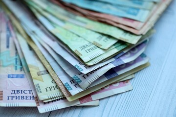 Big amount of different ukrainian hryvnia currency money bills on wooden background