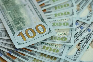 Many hundred dollar bills new banknotes in big pile under the natural light