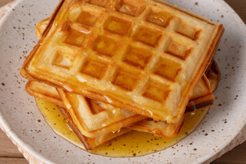 Delicious waffles served with honey drizzled on top for a perfect breakfast treat