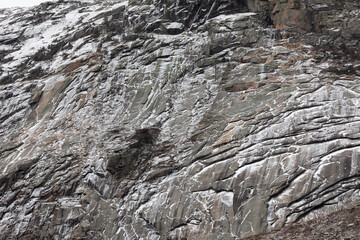 Snow-covered granite cliffs in the White Mountains of New Hampshire. The rugged rock face features dramatic textures, showcasing the region’s natural beauty and appeal for hikers and climbers