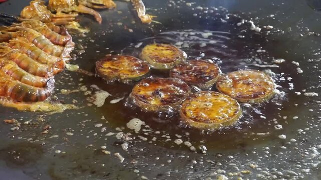 Hilsha fish is fried in a big pan along with shrimp and eggplant, Hilsha Fish and shrimp Simmering in mustard oil, traditional Bengali style fried hilsa and eggplant