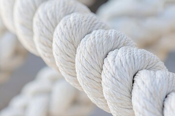 White, thick rope background with a textured, coiled rope pattern. Close-up of a boating rope with multiple strands and a braided design. White background. Textured, white background with a close-up.
